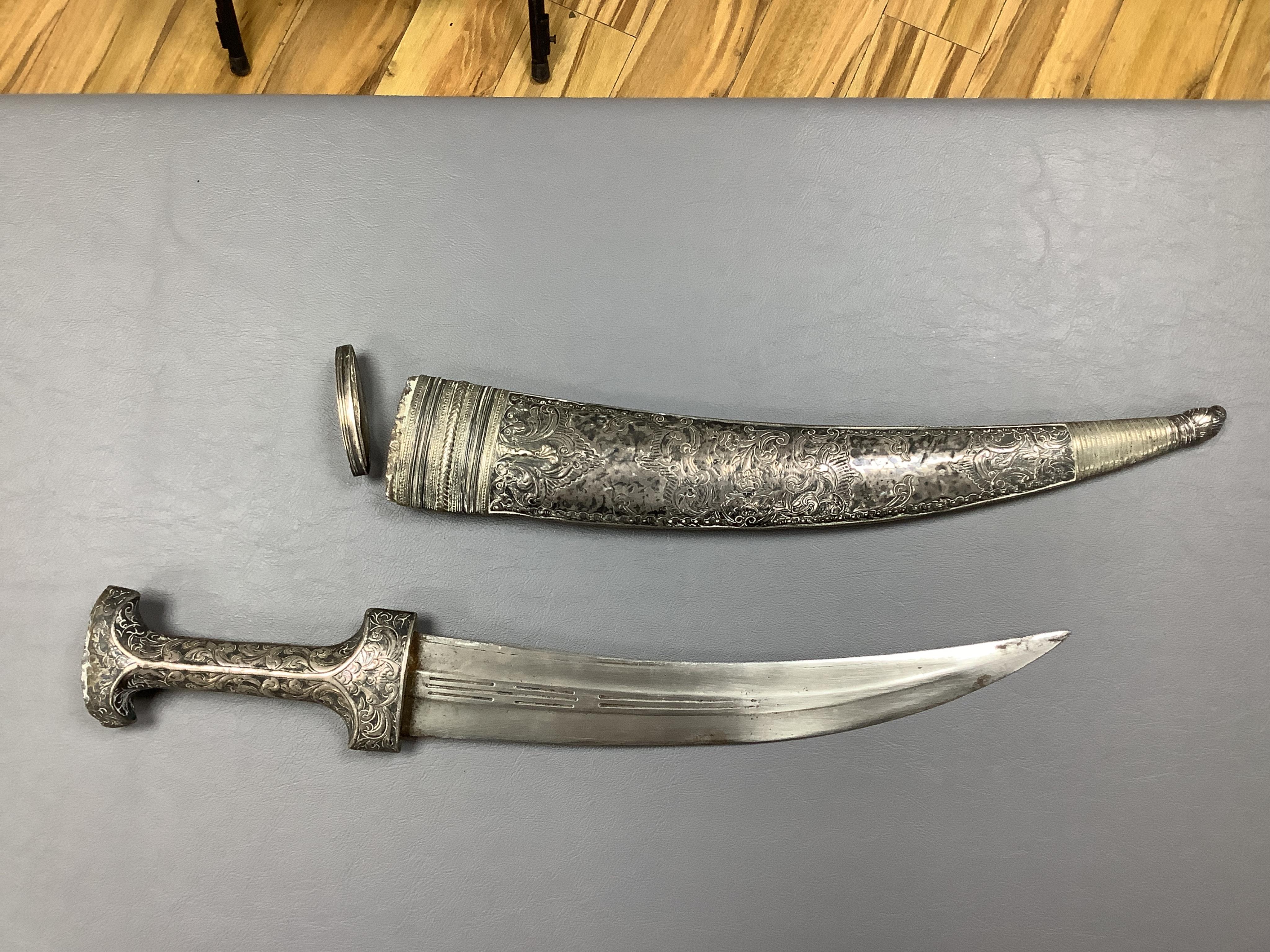 Eighteen assorted world weapons comprising a silver jambya (pommel missing), a knobkerry, a dha, two kris (one with handle missing), a lohar, three kukris, a djambok, a Chinese trousse, a chora, a flyssa, five others and